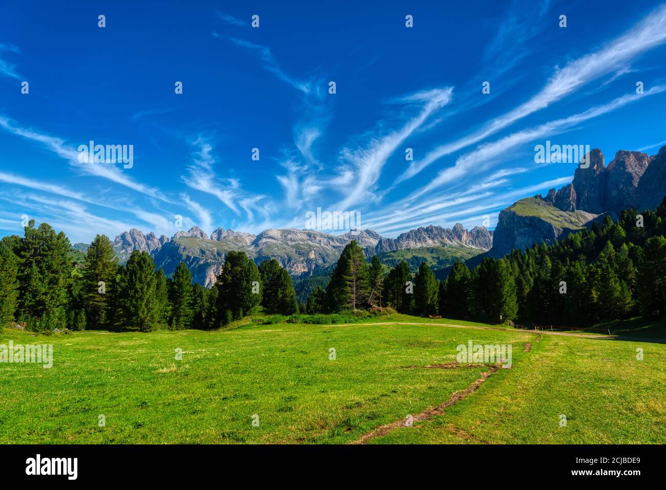 Paysage de prairie verte et montagnes de la vallée de Gardena dans un matin d'été avec des nuages scéniques dans le ciel, Dolomites Banque D'Images