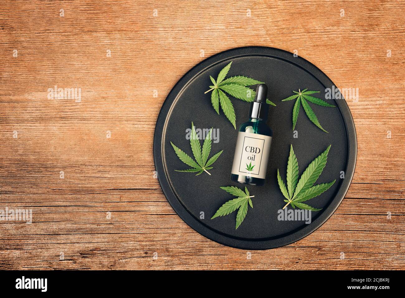 Cannabis produit médical, huile de CBD, avec feuilles de chanvre sur une table en bois Banque D'Images