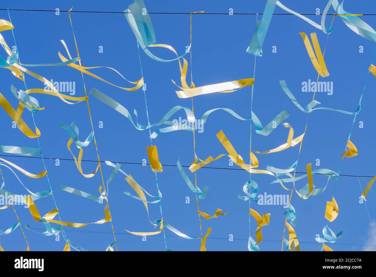 arrière-plan festif - rubans de satin bleu et doré contre le ciel bleu. Banque D'Images