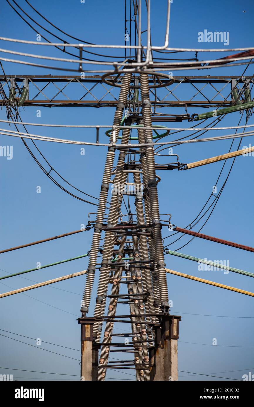 Isolants et fils sur la tour électrique sur la sous-station électrique. Équipement haute tension sur ciel bleu. Gros plan Banque D'Images