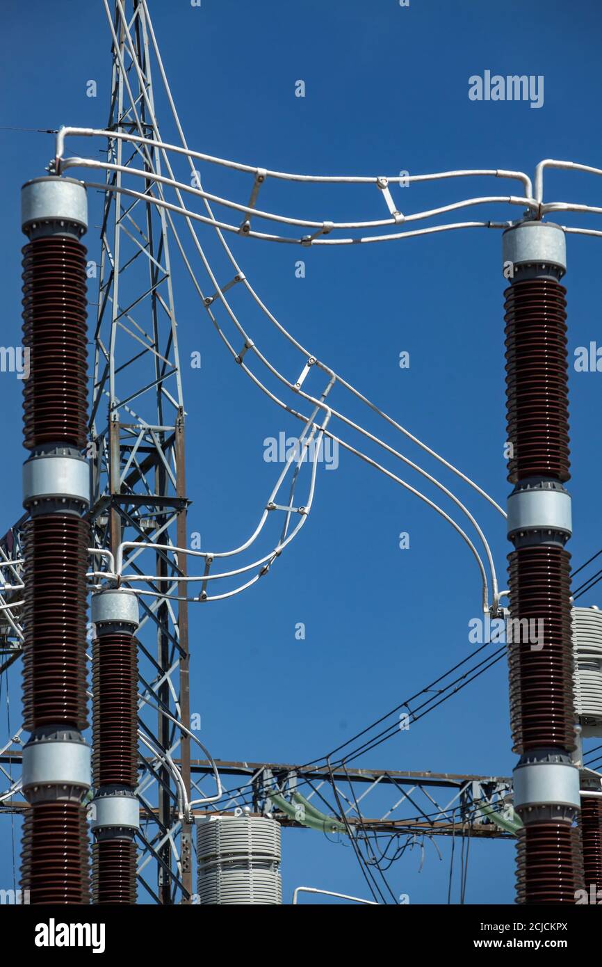 Gros plan des isolateurs (isolateurs) et des câbles sur la sous-station du transformateur de la centrale électrique. Équipement haute tension. Fond bleu ciel Banque D'Images