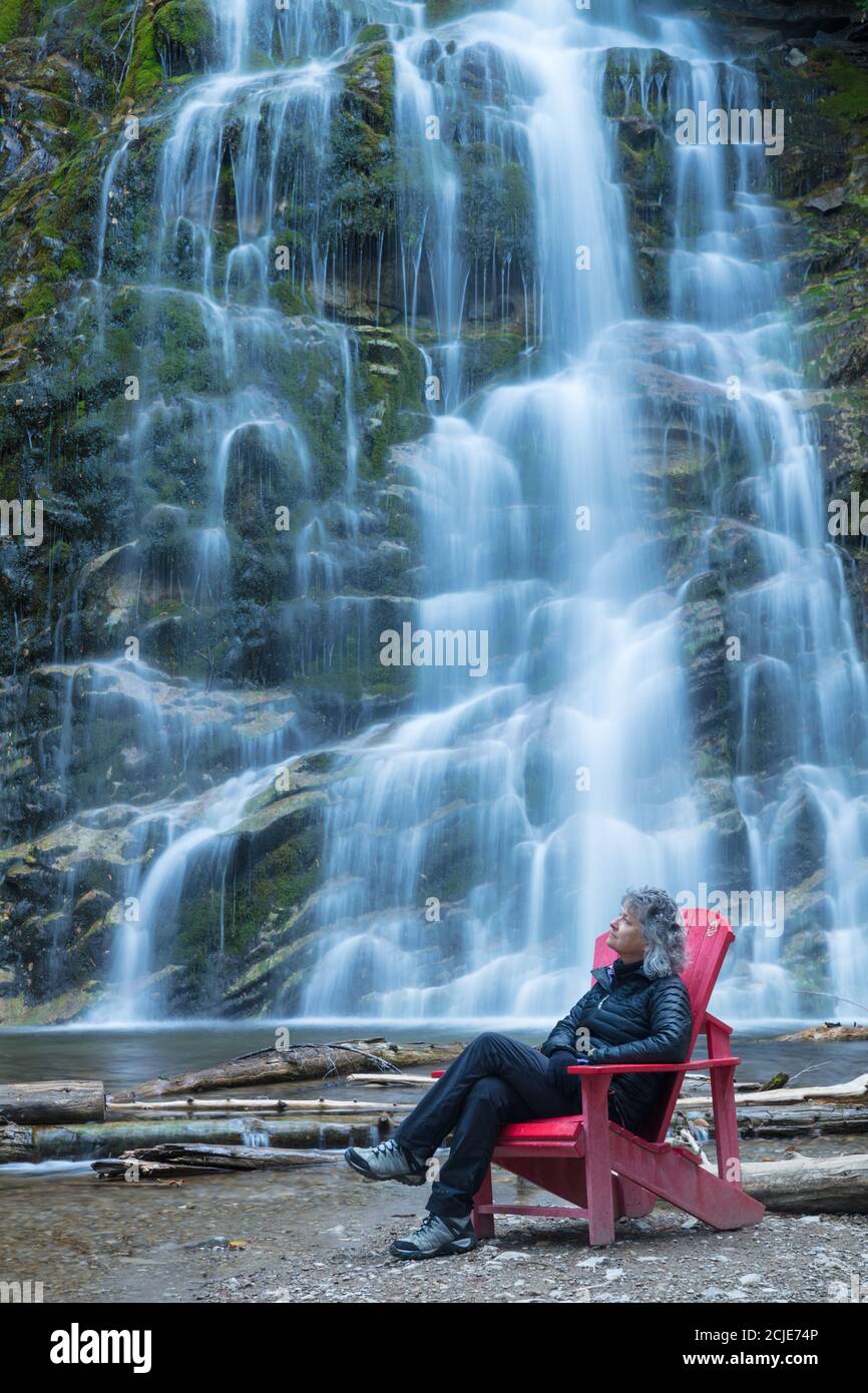 Femme à la chaise rouge de la chute, parc national Forillon, Gaspésie, Québec, Canada Banque D'Images