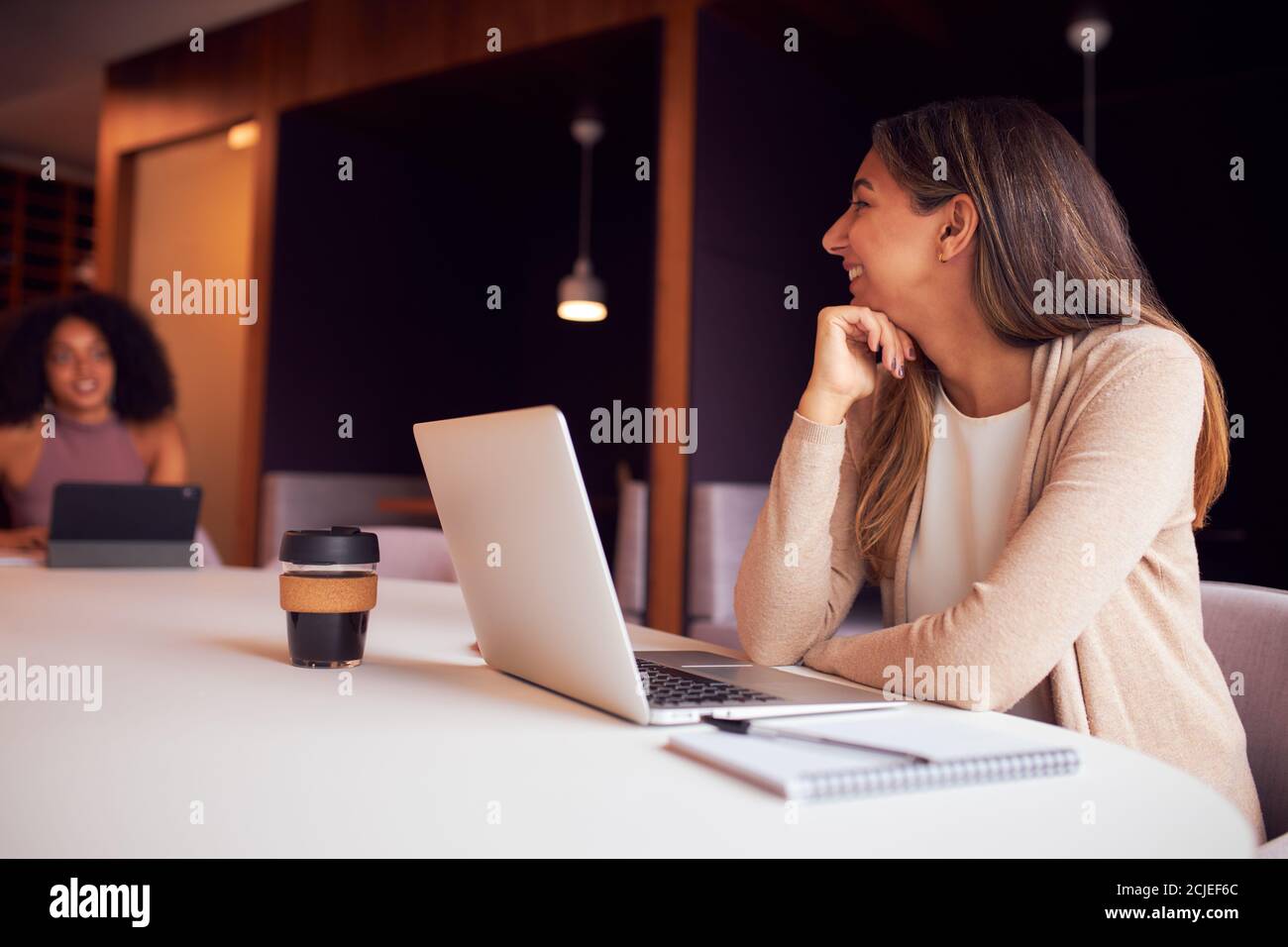 Femme d'affaires avec ordinateur portable lors d'une réunion sociale à distance au bureau pendant Pandémie de santé Banque D'Images
