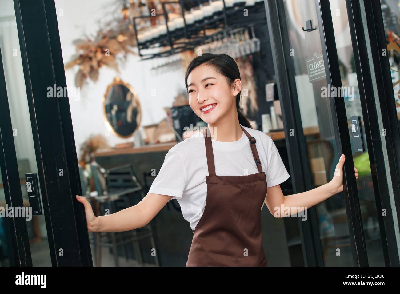 Debout à la porte de la serveuse du café Banque D'Images