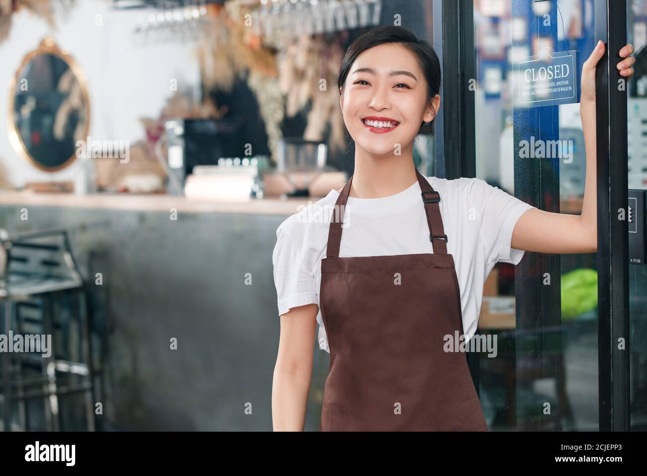 Debout à la porte de la serveuse du café Banque D'Images