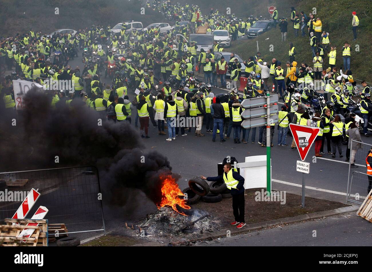Des manifestants portant des gilets jaunes, symbole d'une protestation des  chauffeurs français contre la hausse du prix du carburant, assistent à une  manifestation à l'entrée d'un centre commercial à Nantes, France, le