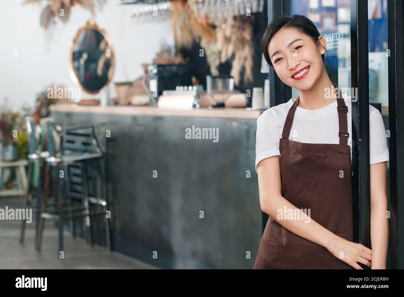 Debout à la porte de la serveuse du café Banque D'Images
