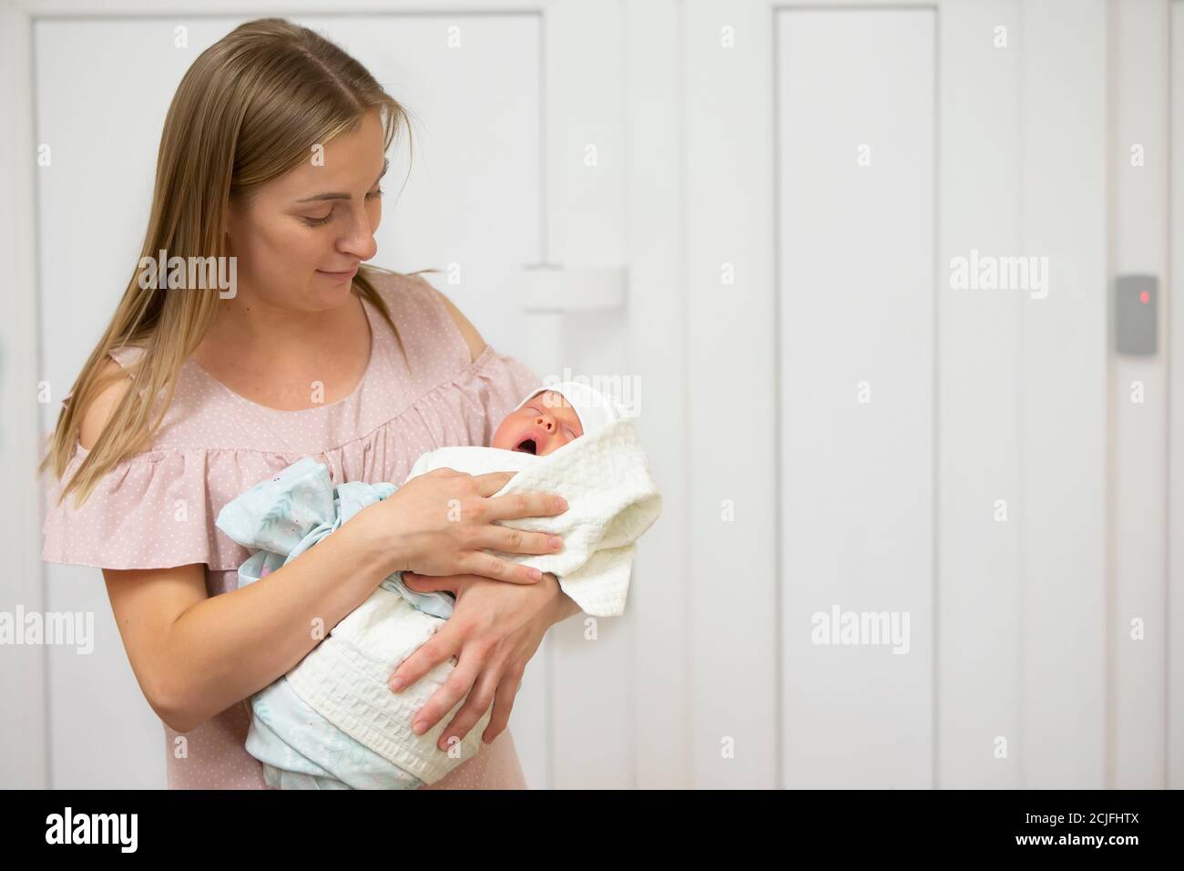 Une jeune mère tient un nouveau-né dans les bras dans un hôpital de maternité. Banque D'Images