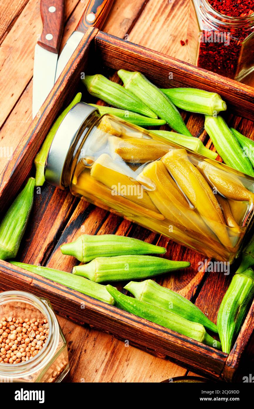 Gousses d'okra en conserve dans un pot en verre. Légumes salés marinés faits maison. Banque D'Images