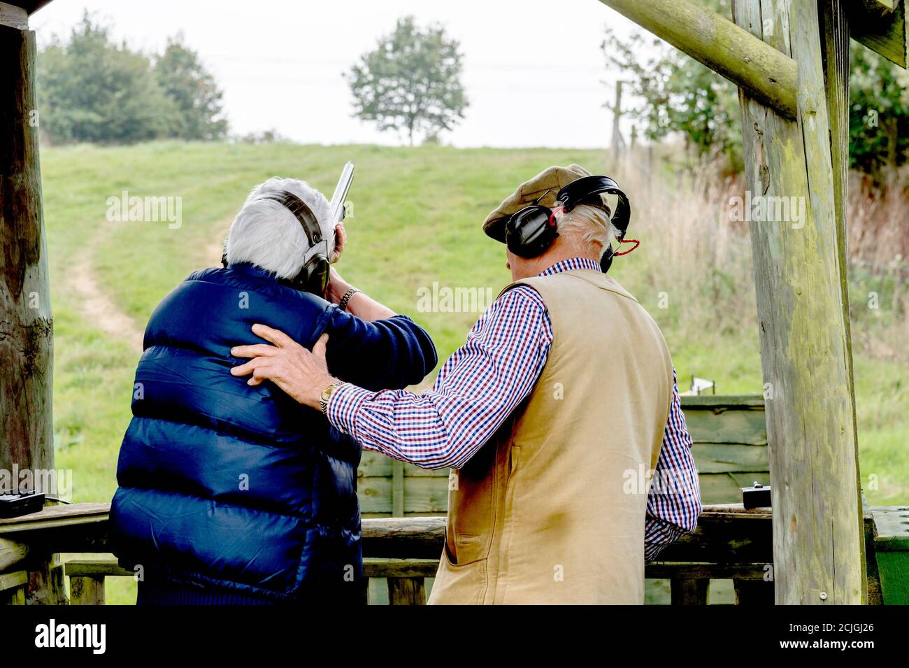 Femme le tir au pigeon d'argile avec de l'enseignement ; Frau beim Tontaubenschießen mit Unterweisung Banque D'Images