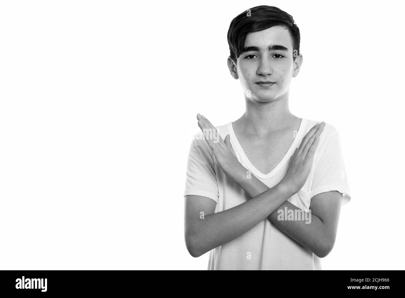 Photo studio d'un jeune adolescent persan charmant montrant un arrêt mouvement de la main avec les deux mains Banque D'Images