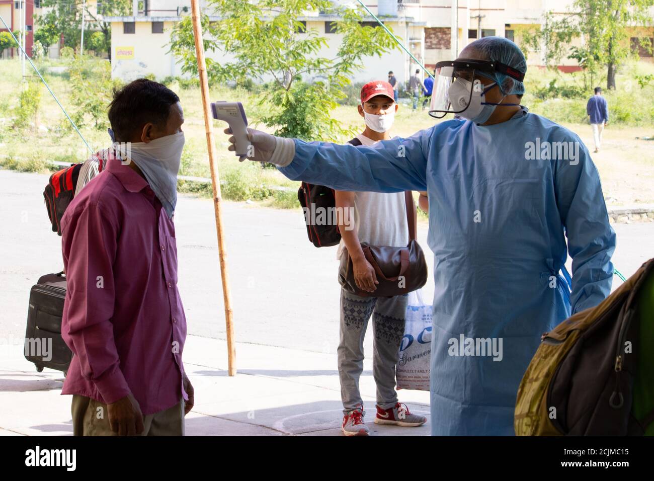 Dehradun, Uttarakhand/India - septembre 10 2020:UN médecin vérifiant la température des migrants, portant un équipement de protection individuelle et un masque facial. Banque D'Images