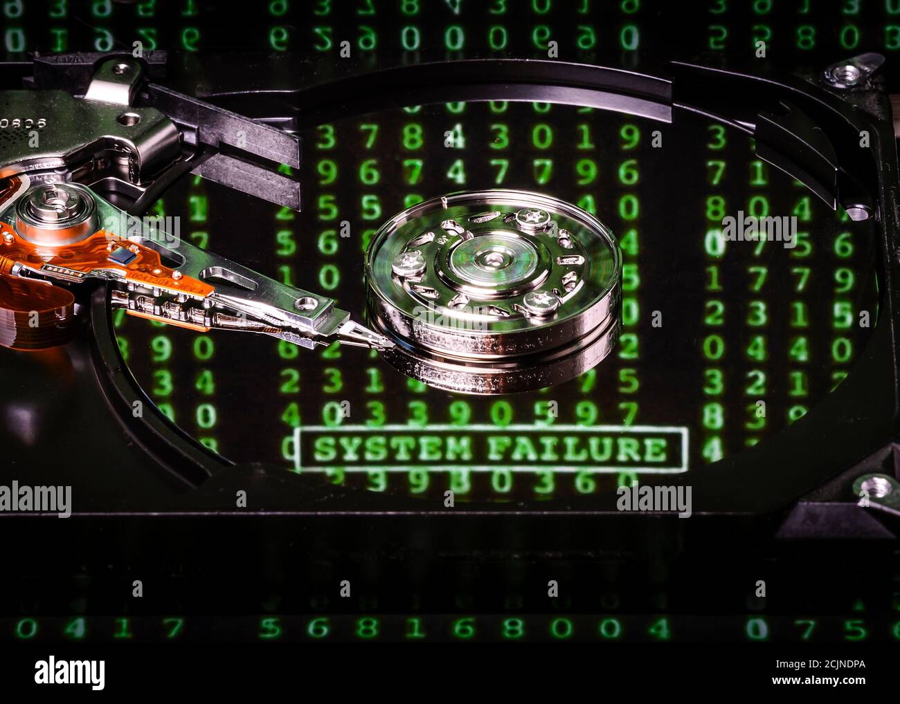 Mécanisme d'un disque dur d'ordinateur avec un mot vert flou 'défaillance  du système' et des chiffres reflétés sur la surface métallique du disque.  Le Photo Stock - Alamy