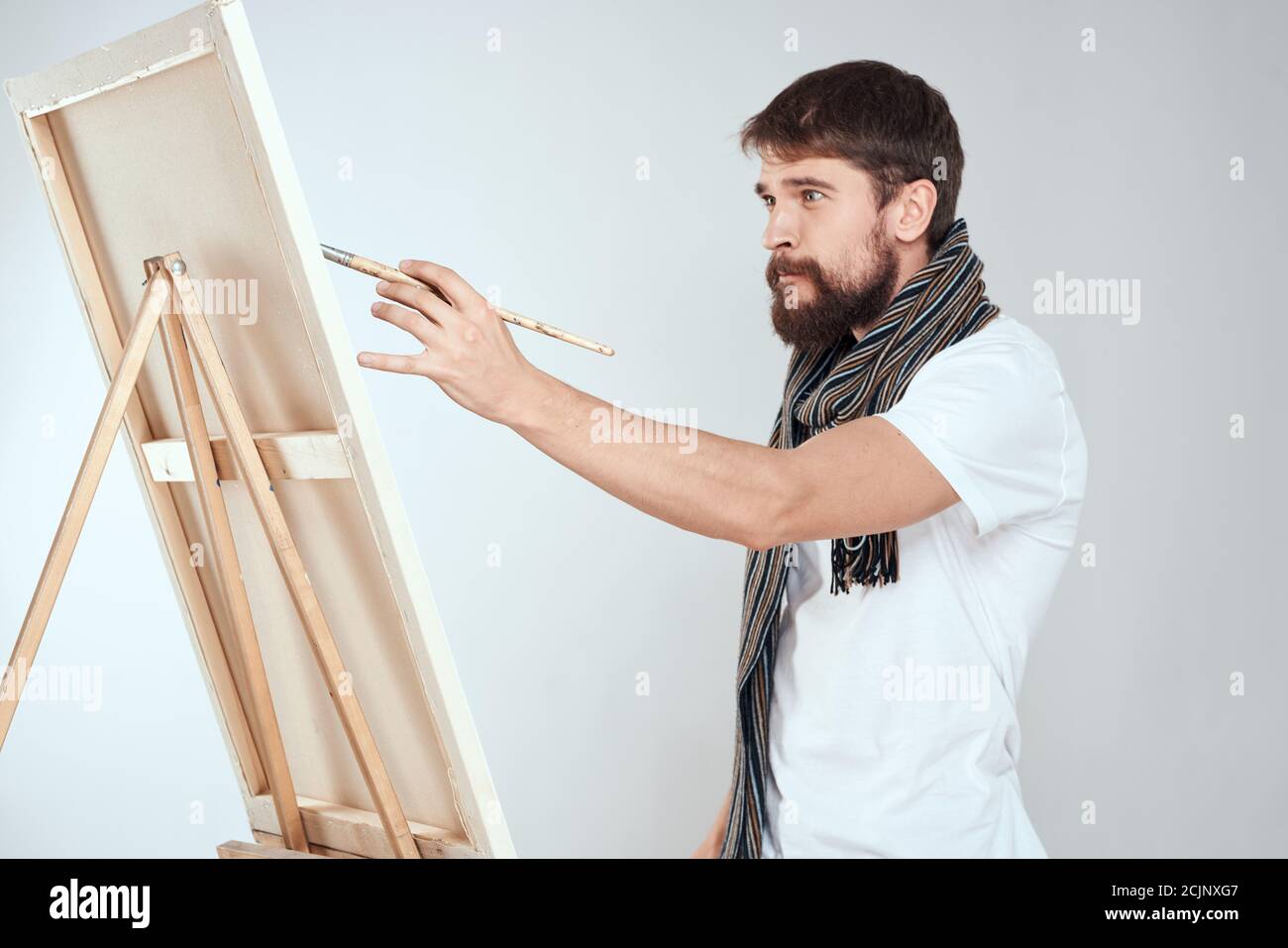 Un artiste d'homme tire sur un chevalet un foulard blanc t-shirt art hobby  créativité Photo Stock - Alamy