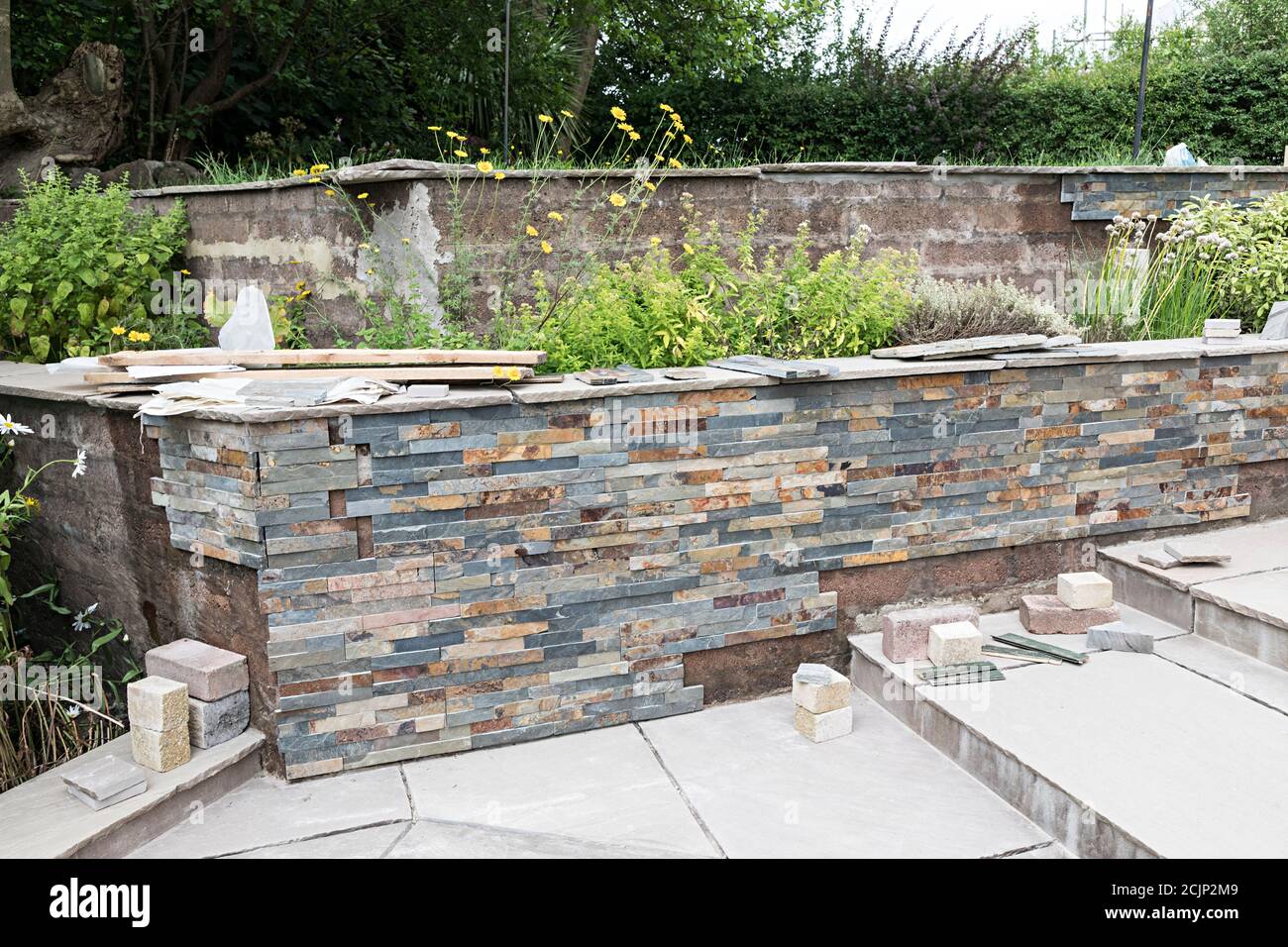 Le revêtement en pierre est installé sur le mur de soutènement du jardin, Royaume-Uni Banque D'Images