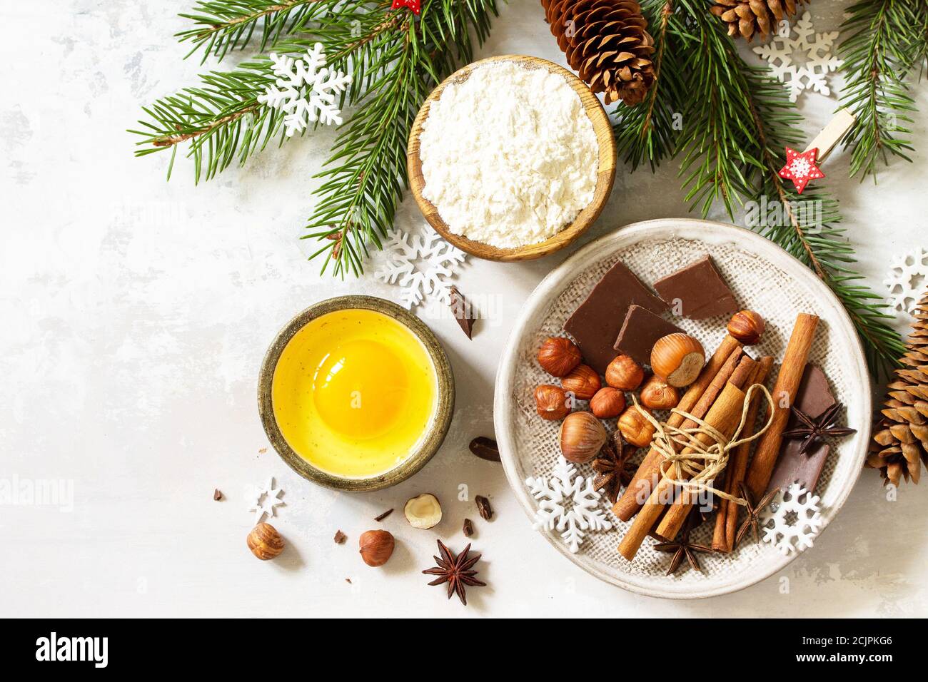 Cuisine de saison fond d'hiver. Ingrédients pour la cuisson de Noël - chocolat, épices, noix, farine et œufs sur fond de pierre. Plan d'étapage avec vue de dessus Banque D'Images
