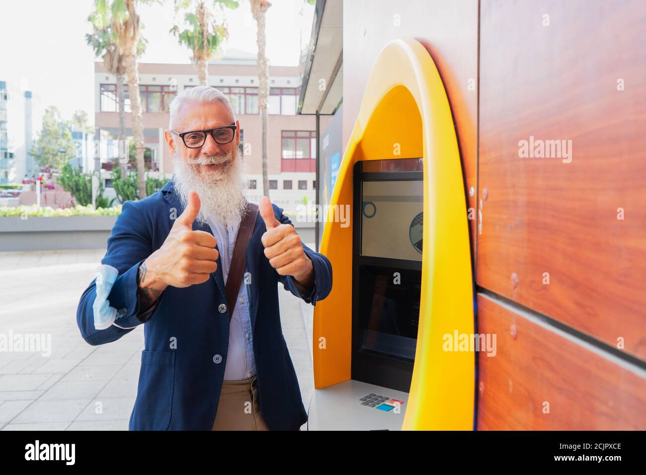 Homme senior avec ATM Banque D'Images
