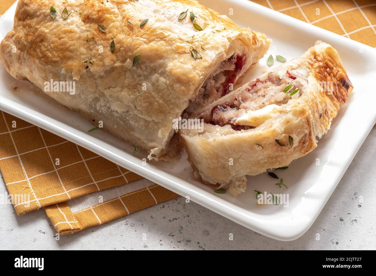 Petits pains de saucisse de dinde de porc cuits au fromage de brie et aux canneberges sauce dans une pâte feuilletée Banque D'Images