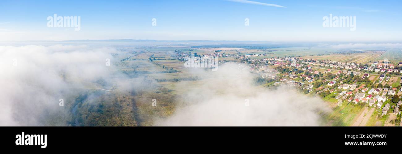 Vue aérienne de drone de campagne pittoresque en automne ensoleillé et brumeux jour. Vue panoramique sur le village ukrainien traditionnel Banque D'Images