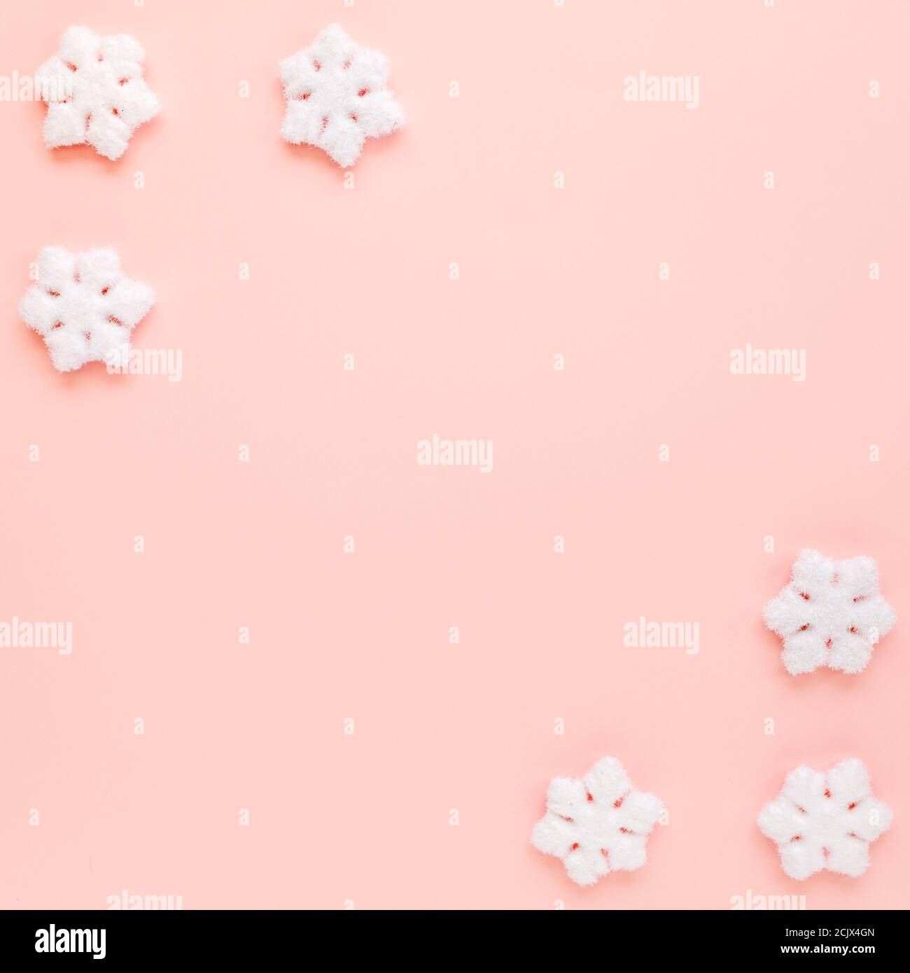 Cadre de Noël avec flocons de neige blancs sur fond rose. Composition de Noël, papier peint. Flat lay, vue de dessus Banque D'Images Cadre de Noël avec flocons de neige blancs sur fond rose. Composition de Noël, papier peint. Flat lay, vue de dessus Banque D'Images
