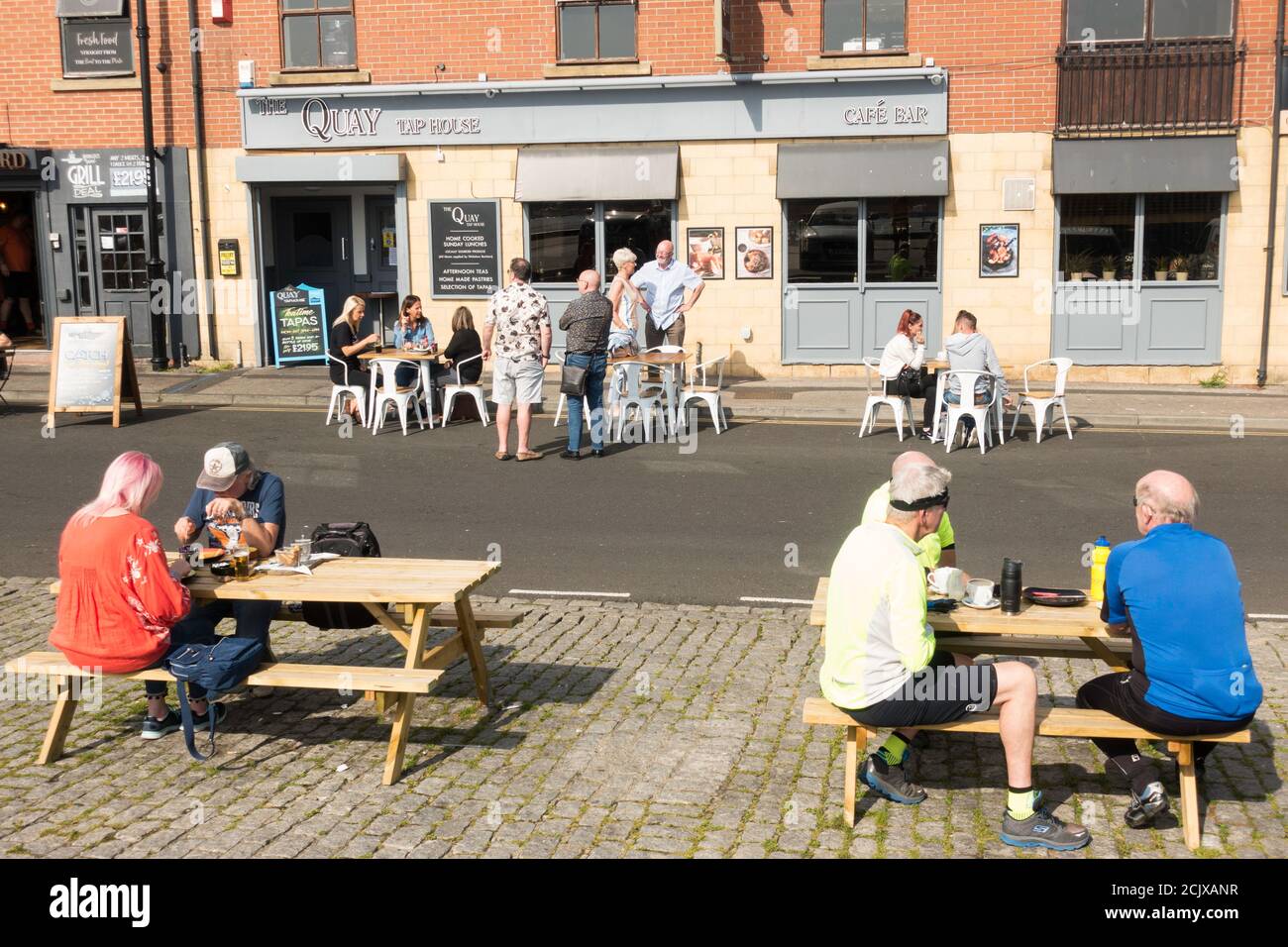 Les personnes qui mangent à l'extérieur du restaurant Quay Tap House sur North Shields Fish Quay, Angleterre, Royaume-Uni Banque D'Images