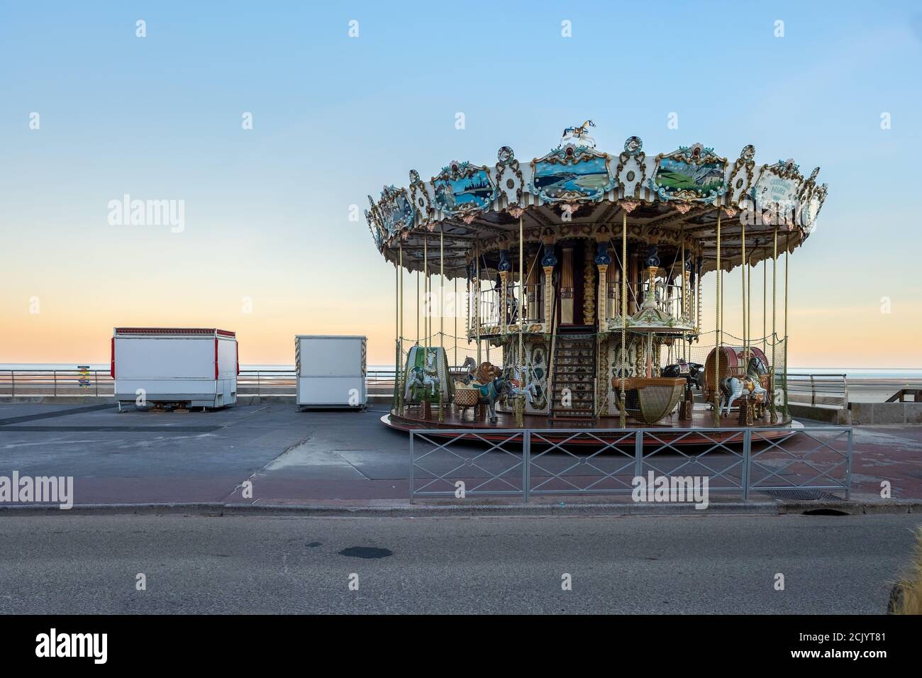 Carrousel d'époque à côté de la plage au lever du soleil. Banque D'Images
