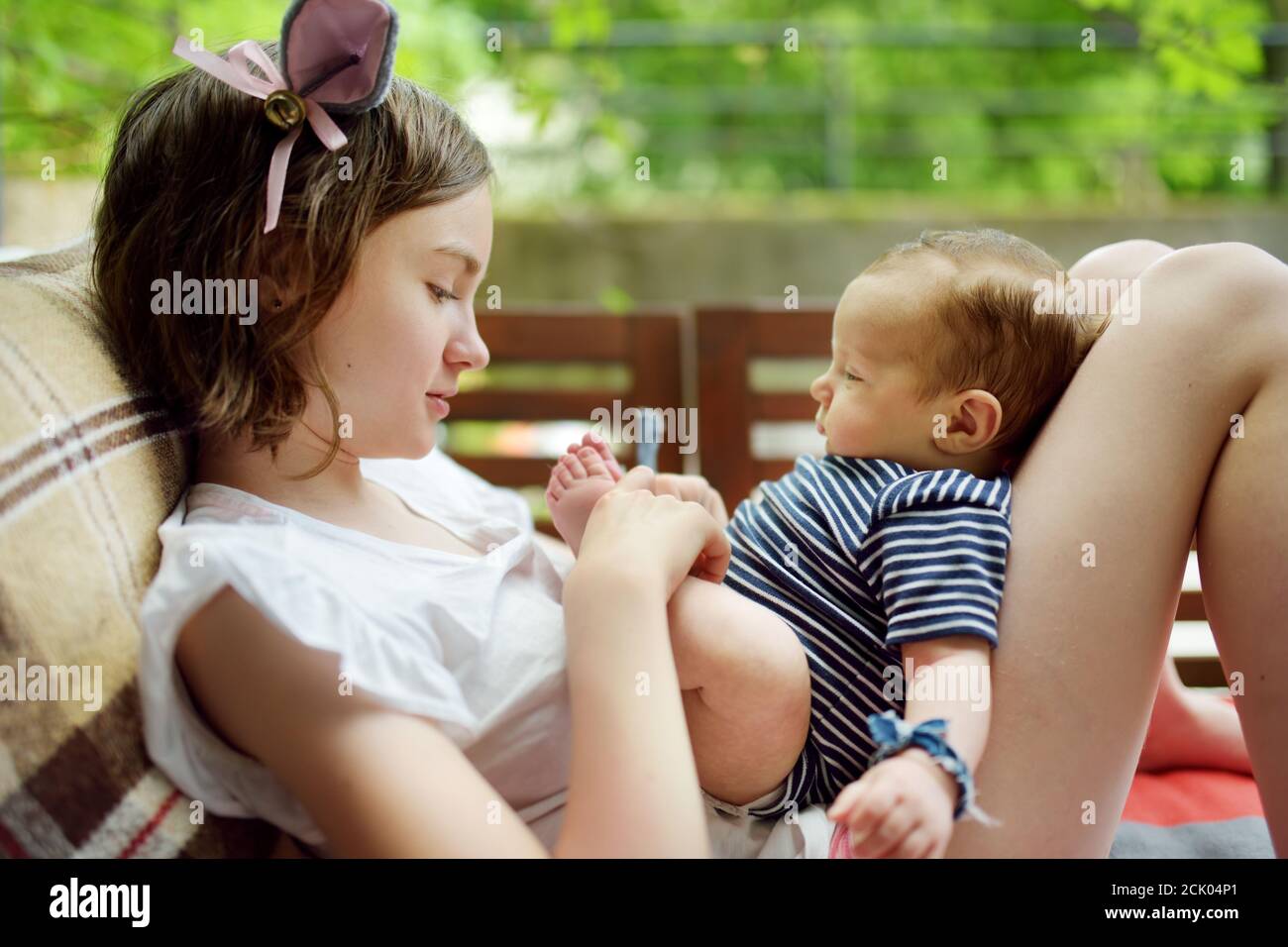 Jolie grande sœur admirant son petit frère. Adorable adolescente tenant son nouveau frère de garçon. Enfants avec une grande tranche d'âge. Grande différence d'âge entre Banque D'Images