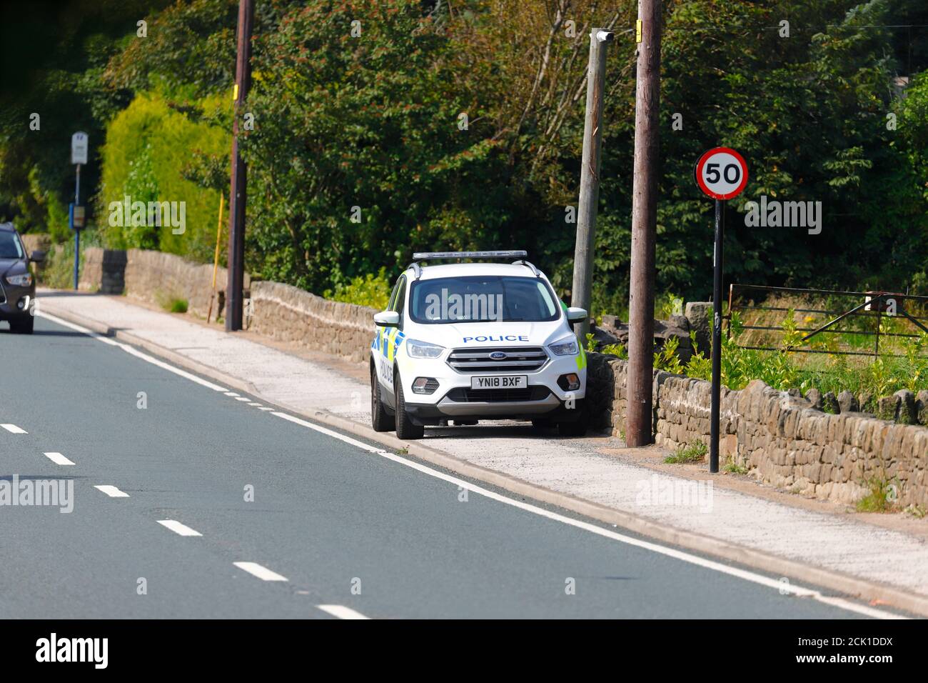 Un véhicule de police Ford Kuga stationné sur un sentier de Sheffield, dans le Yorkshire du Sud, tandis que les officiers se tiennent à l'arrière pour attraper les automobilistes en vitesse rapide. Banque D'Images