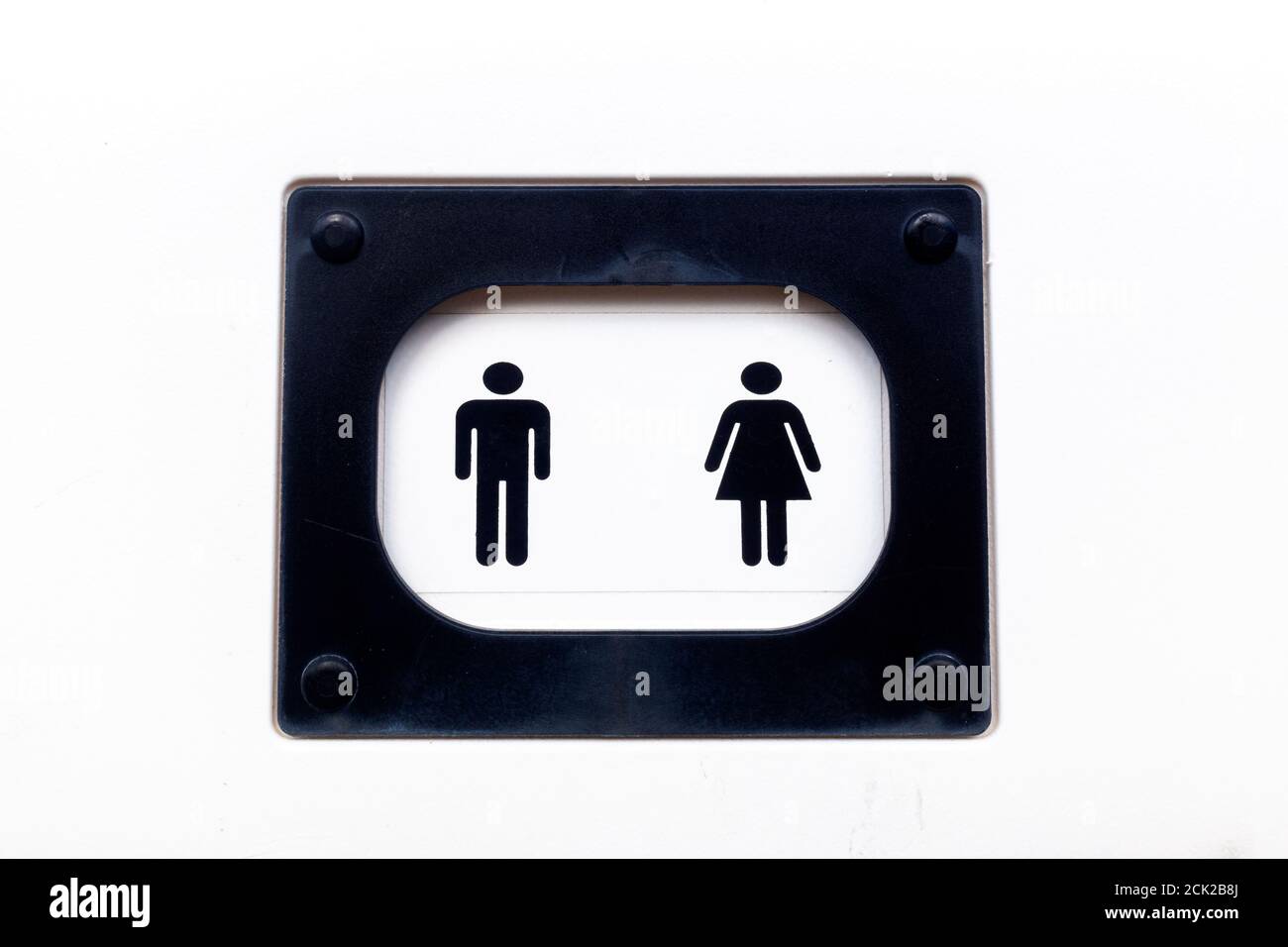 Icônes de l'homme et de la femme à la porte d'une toilette publique aux murs blancs. Banque D'Images