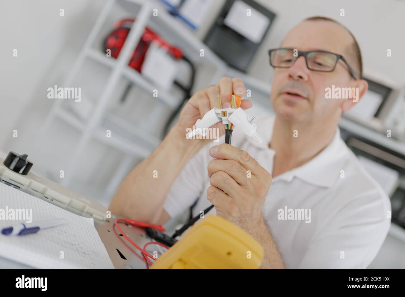 un employé qui teste des composants électriques Banque D'Images
