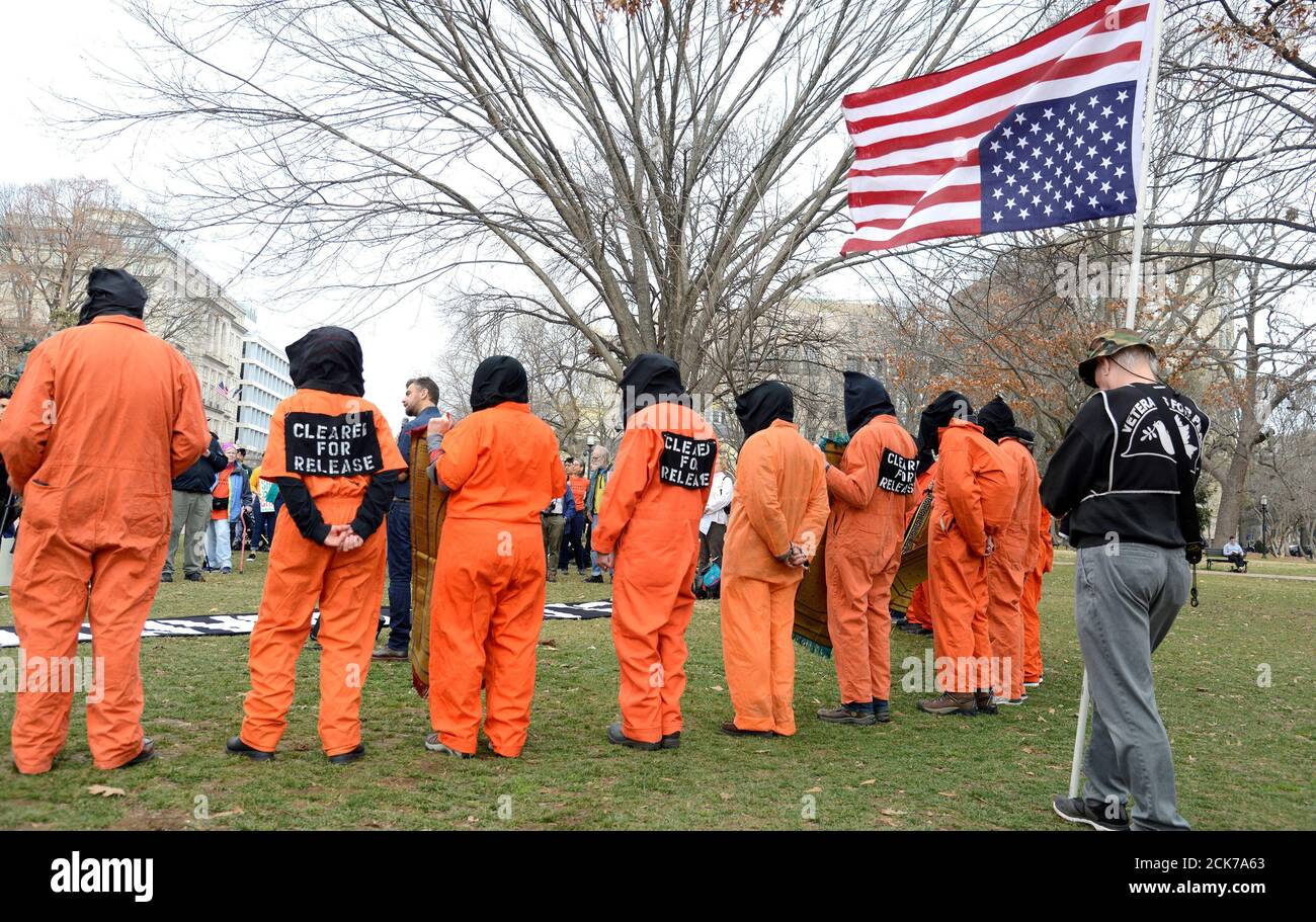 Des activistes portant des combinaisons de prison et des capots noirs  participent à une manifestation contre le camp de détention de Guantanamo  Bay, ouvert il y a 18 ans, et appellent à