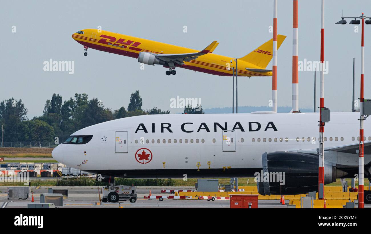 Richmond, Colombie-Britannique, Canada. 31 juillet 2020. Un cargo DHL Express Boeing 767 (N739DH), exploité par Kalitta Air, prend son départ de l'aéroport international de Vancouver. Au premier plan se trouve un Boeing 777-200LR d'Air Canada (C-FNNH) mis en entreposage en raison de la pandémie de COVID-19 et de la grave baisse subséquente du transport aérien. Crédit : Bayne Stanley/ZUMA Wire/Alay Live News Banque D'Images