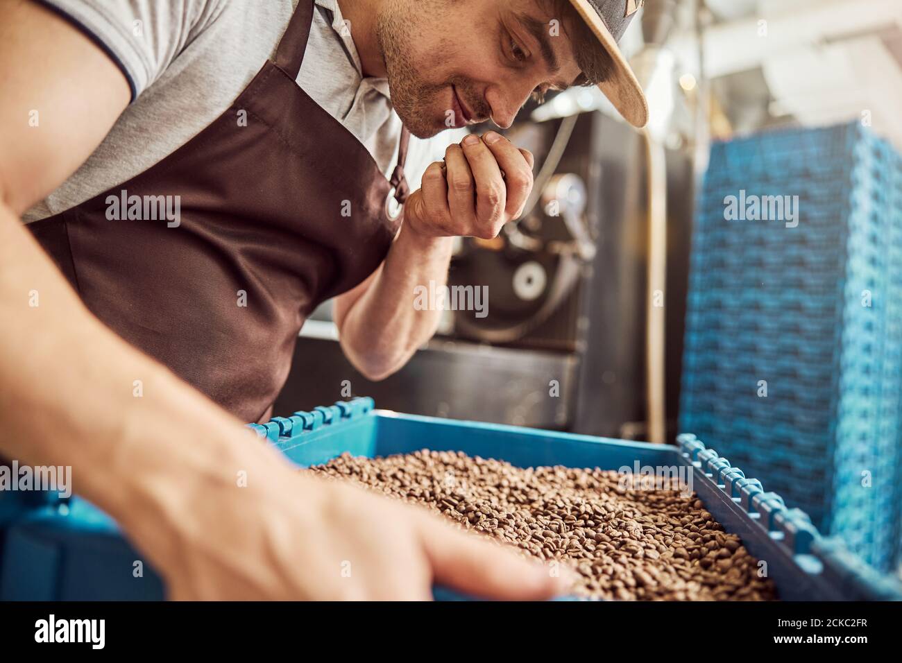 Un homme charmant qui sent les grains de café torréfiés Banque D'Images