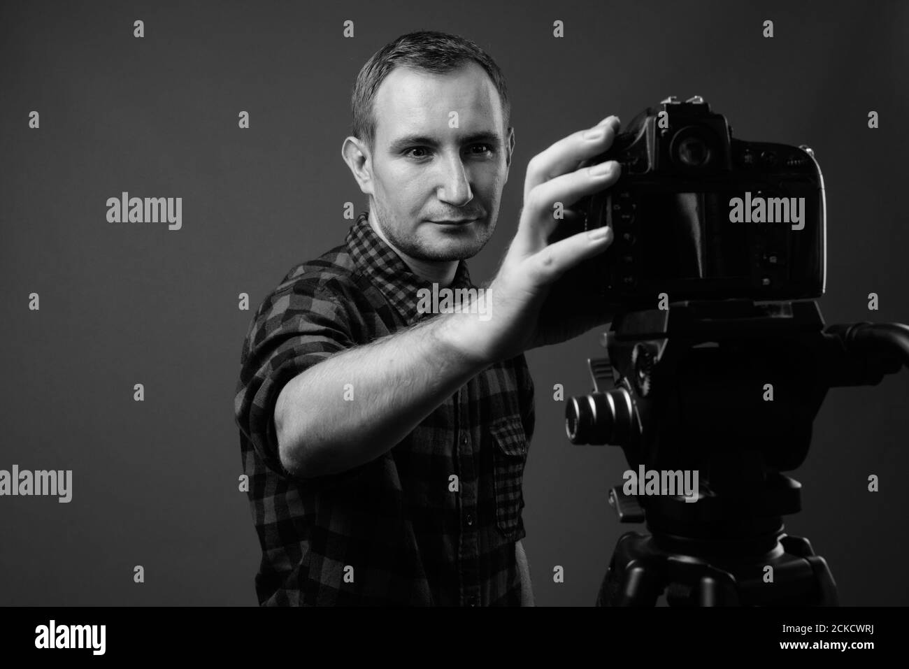 Portrait de l'homme hipster vlogging avec l'appareil photo sur fond gris Banque D'Images