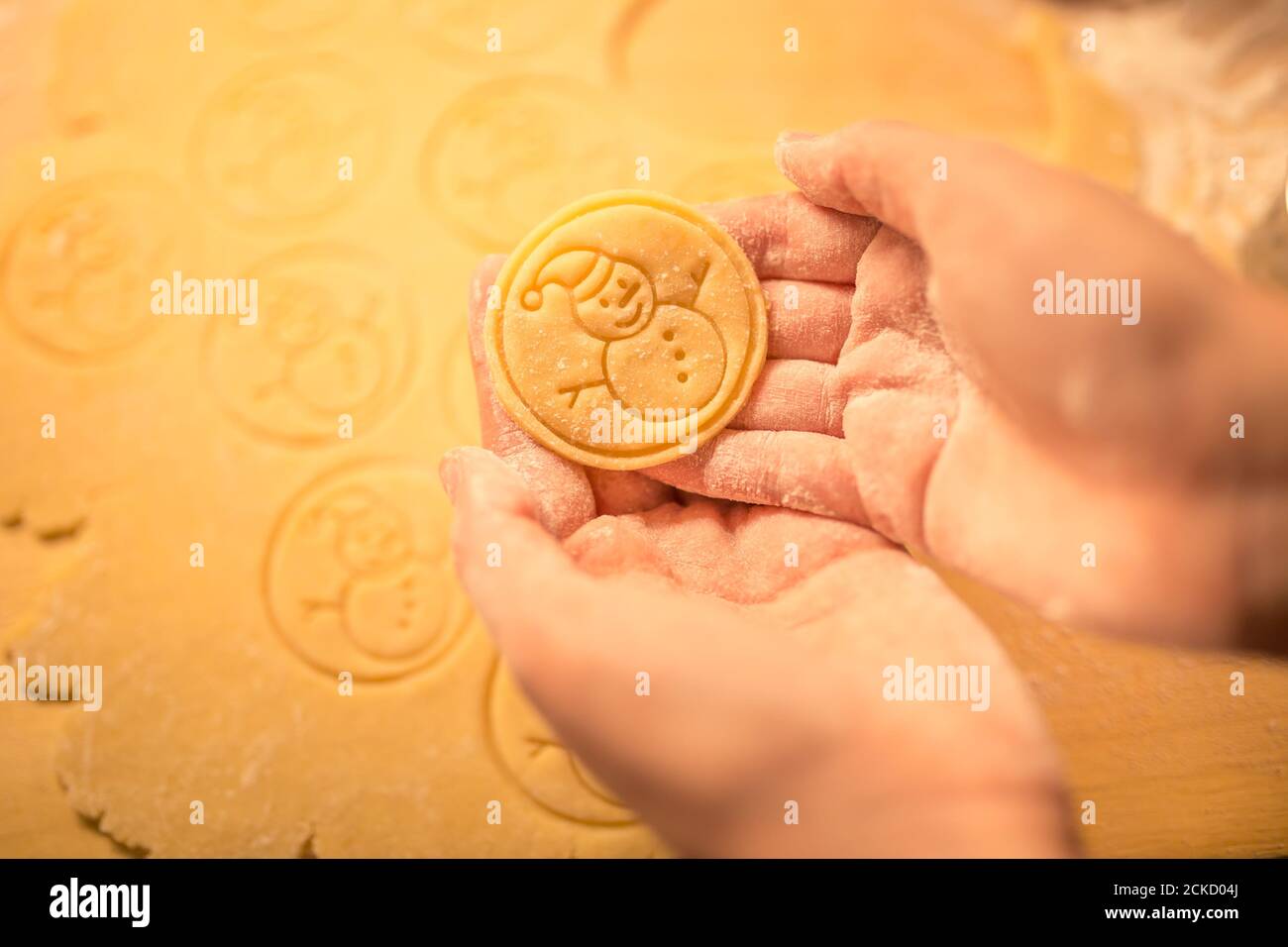 La Pâte à biscuits de Noël en sucre estampillé, fait avec amour, bonhomme de thème. Guerre Sinhle cookie dans les mains de womans. Des bonbons de Noël. Banque D'Images