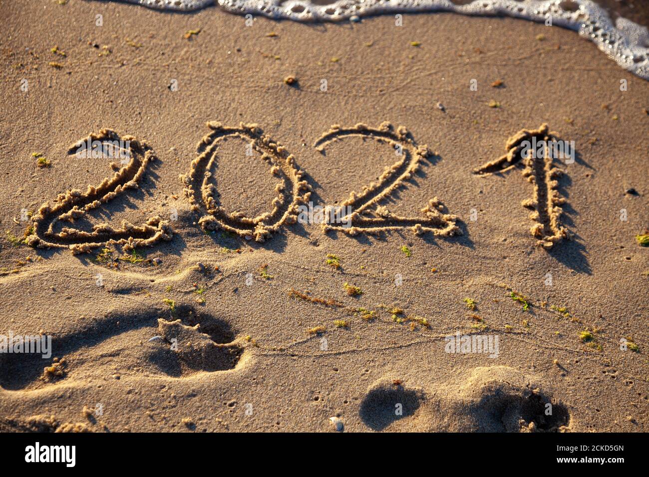 Les chiffres 2021 sont écrits dans le sable. Nouvel an sur la plage. Côte de mer, vague. Arrière-plan naturel. Place pour votre texte. Été en hiver. Banque D'Images