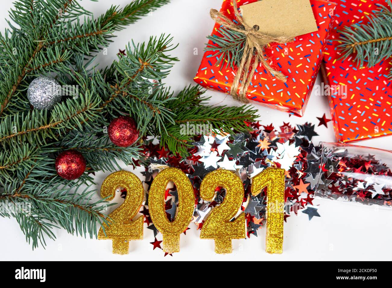 Arrière-plan de vacances avec le texte du numéro d'or 2021, confetti, boîte-cadeau et branche d'arbre de Noël sont sur le fond. Bonne année et bonne année Banque D'Images