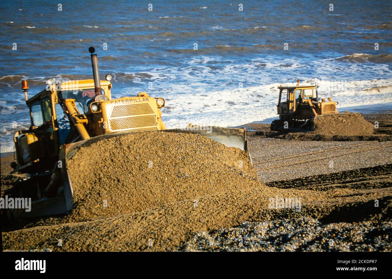Utiliser des bulldozers pour construire la plage de tempête près de CLEY sur la côte de Norfolk afin de protéger la terre contre l'inondation par les tempêtes hivernales. Banque D'Images