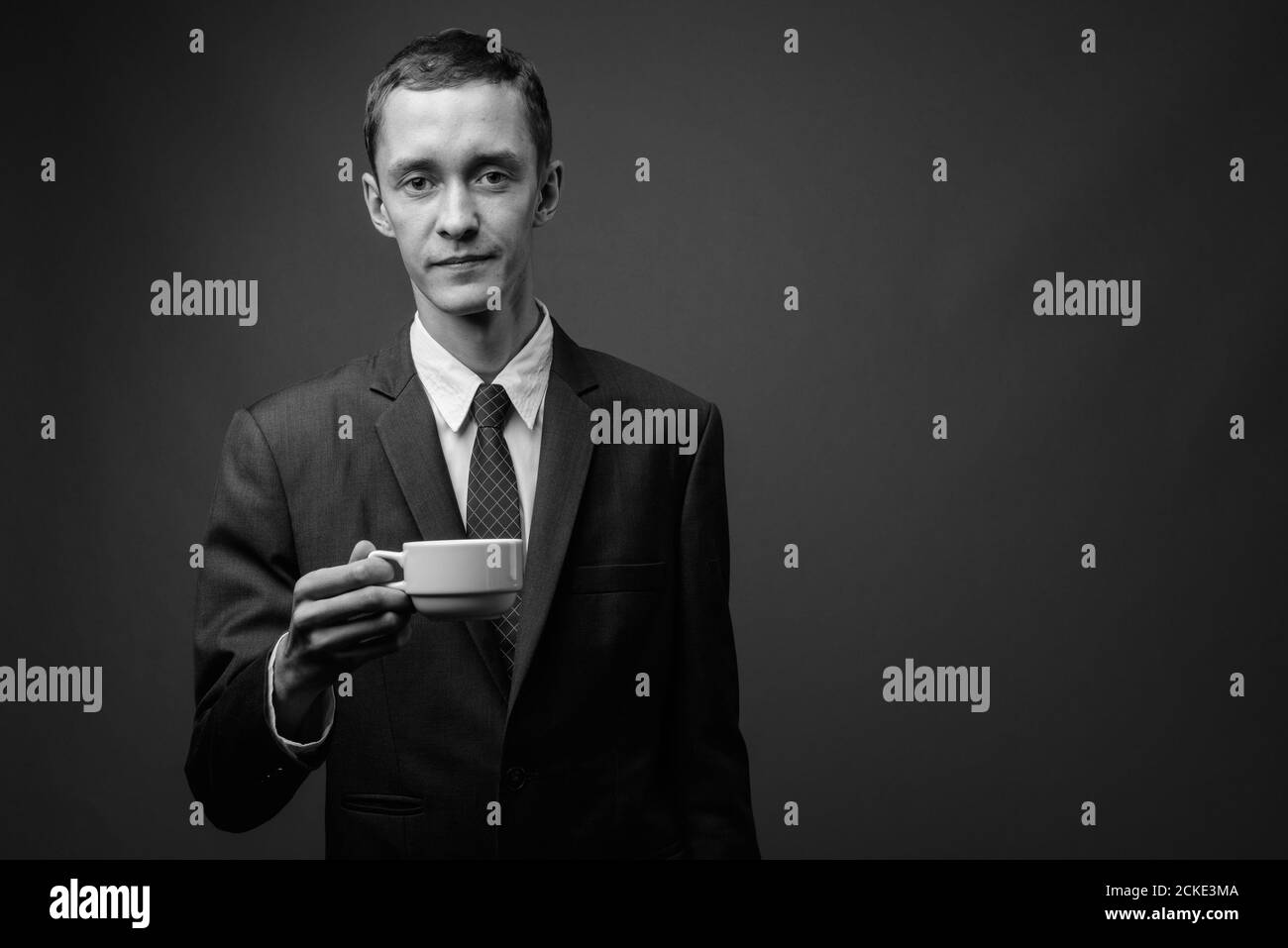 Portrait d'un jeune homme d'affaires en costume avec une tasse de café Banque D'Images