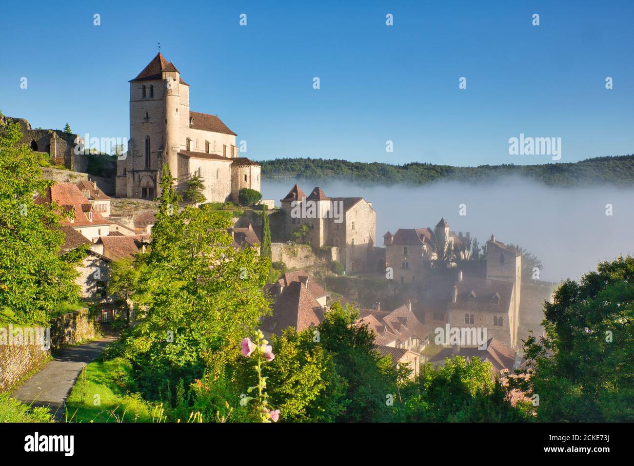 Brume matinale se délaçant du pittoresque village français de St Cirq-Lapopie avec son église, dans le midi-Pyrénées, Lot, Cahors, France Banque D'Images