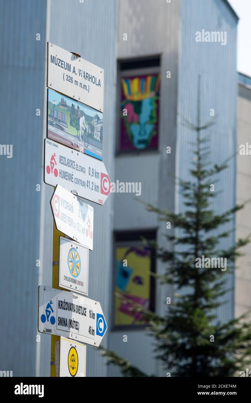 Panneau touristique avec l'inscription « Muzeum A. Warhola ». Bâtiment du musée en arrière-plan. Medzilaborce, Slovaquie orientale, Europe. Banque D'Images