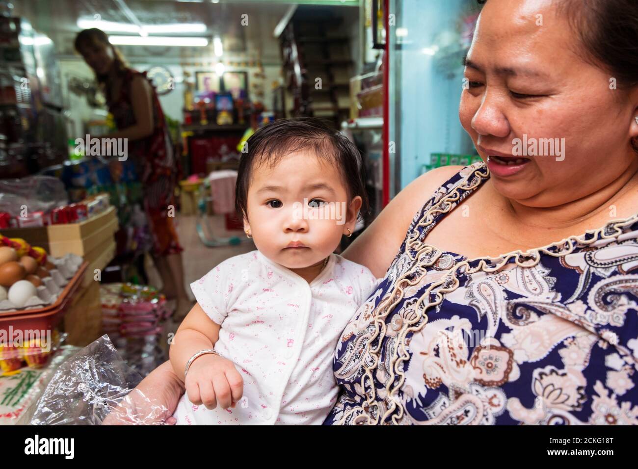 Ho Chi Minh / Vietnam - 25 janvier 2020: Femme vietnamienne grasse tenant une petite fille à l'entrée du magasin Banque D'Images