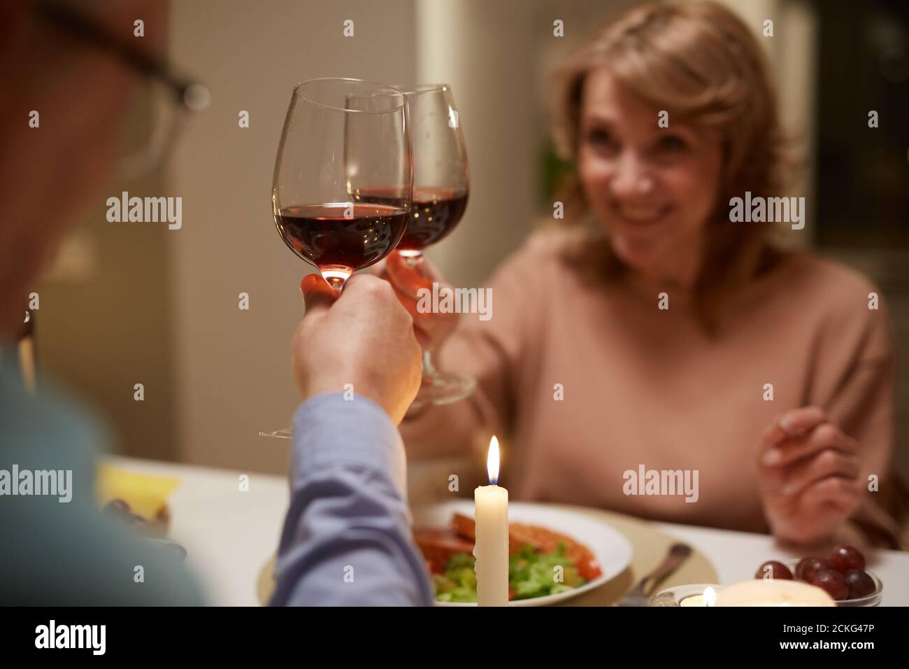 Gros plan de couple avec des verres de vin rouge à la table Banque D'Images