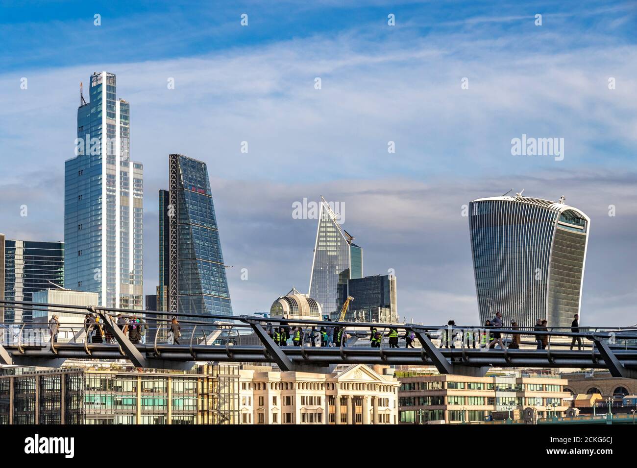 Personnes traversant le Millennium Bridge, une passerelle à travers la Tamise avec la ville de Londres en arrière-plan, Londres, Royaume-Uni Banque D'Images
