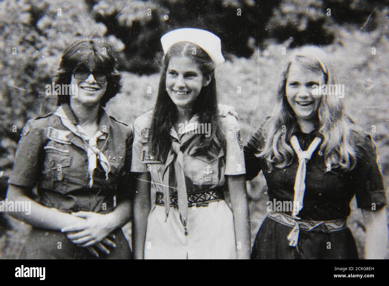 Belle photographie en noir et blanc vintage des années 70 des éclaireuses qui profitent de leur temps en campant au camp de scouts d'été. Banque D'Images