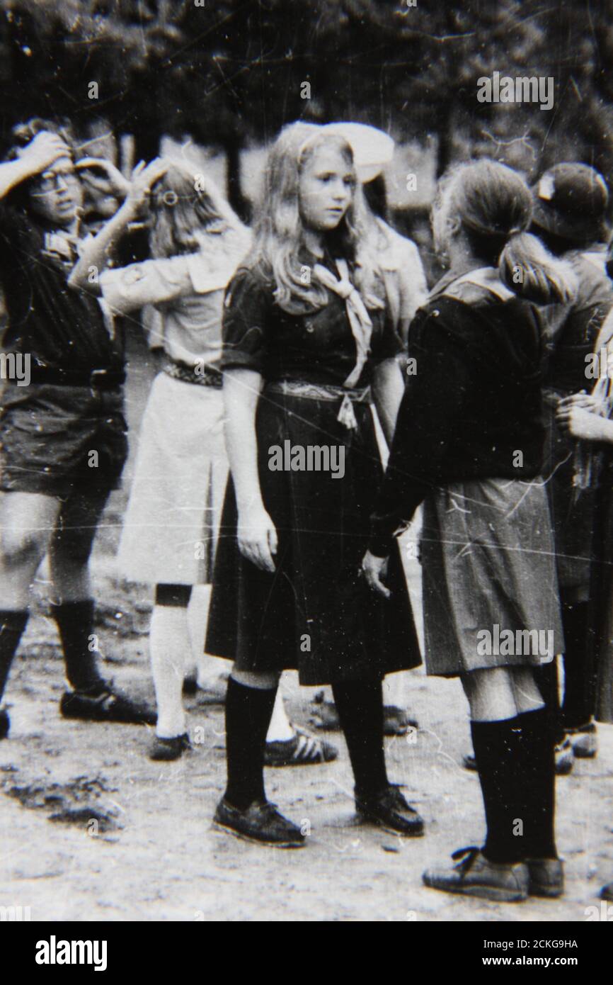Belle photographie en noir et blanc vintage des années 70 des éclaireuses qui profitent de leur temps en campant au camp de scouts d'été. Banque D'Images