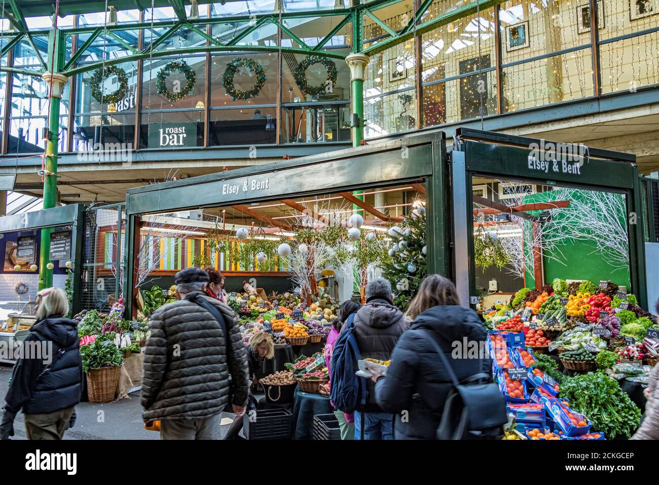 Les gens qui marchent devant un marché aux fruits et légumes stalle dans le Borough Market de Londres, l'un des plus grands et plus anciens marchés alimentaires de Londres Banque D'Images