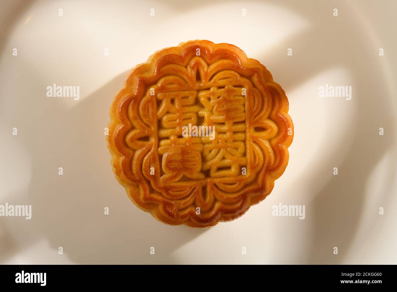 Traduction du chinois en pâte de graines de lotus-anglais avec jaune traditionnel mooncake sur un plat avec la lumière du soleil près d'une fenêtre non logo ou marque commerciale Banque D'Images
