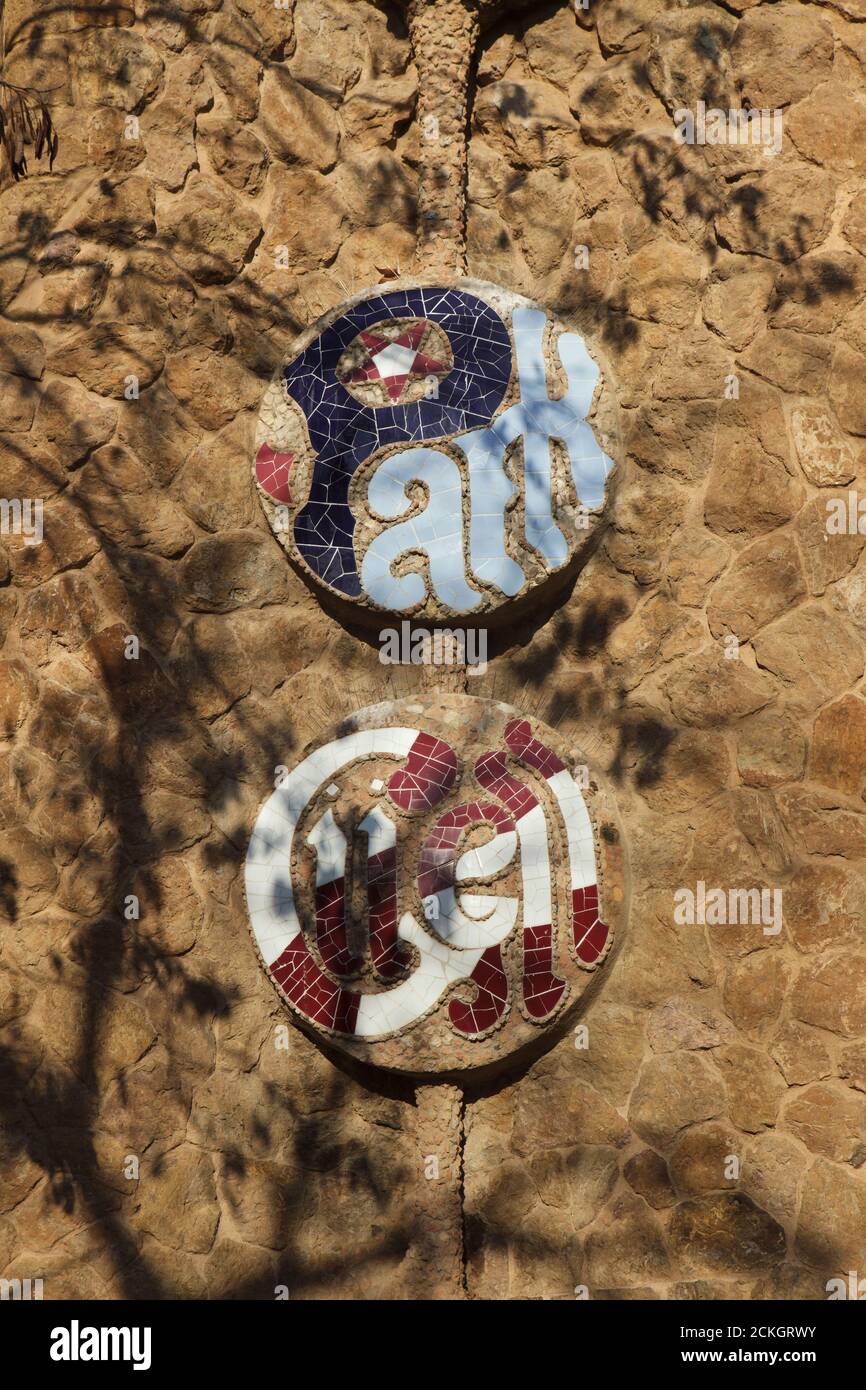 Inscription en mosaïque de Trencadís sur la clôture du Parc Güell conçue par l'architecte moderniste catalan Antoni Gaudí et construite entre 1900 et 1914 à Barcelone, Catalogne, Espagne. Banque D'Images