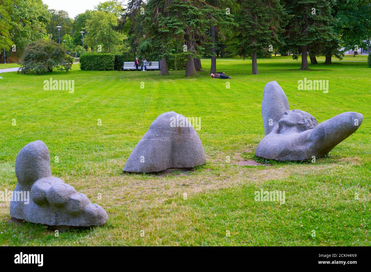 TALLIN, ESTONIE - 15 JUILLET 2019 : les gens se reposent dans un parc municipal avec une sculpture moderne au premier plan Banque D'Images